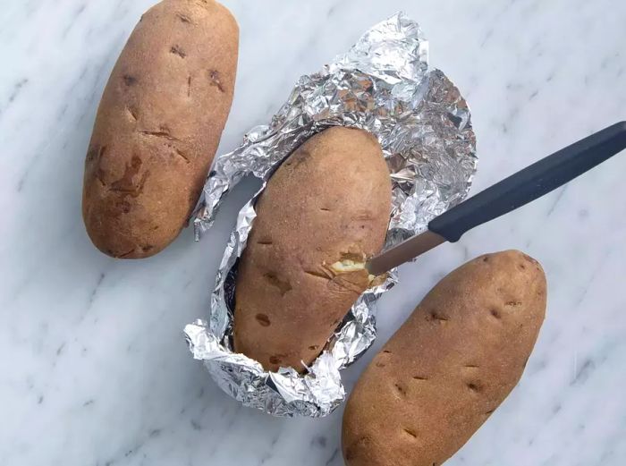 Test the baked potato with a knife to ensure it’s fully cooked through.