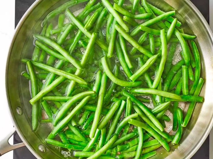 Aerial view of boiling green beans in a pan