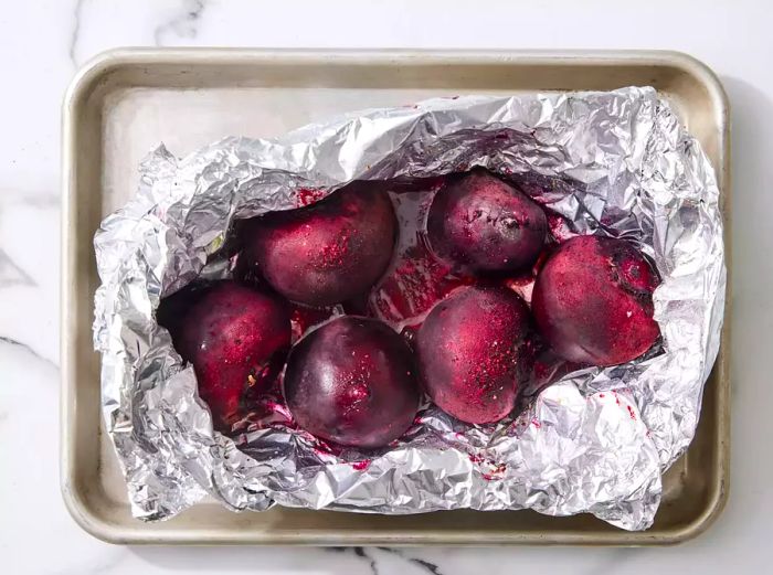 An open foil packet revealing the grilled, seasoned beets inside