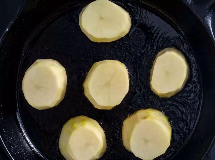 Fondant potatoes sizzling in a skillet