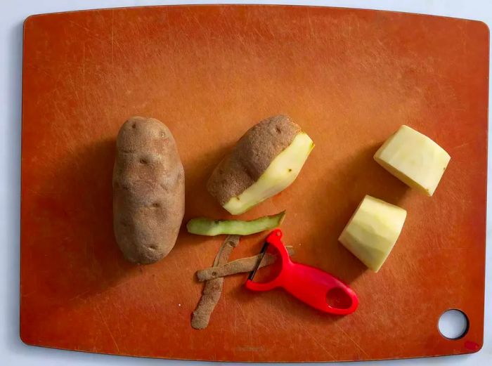 Peeler alongside potatoes