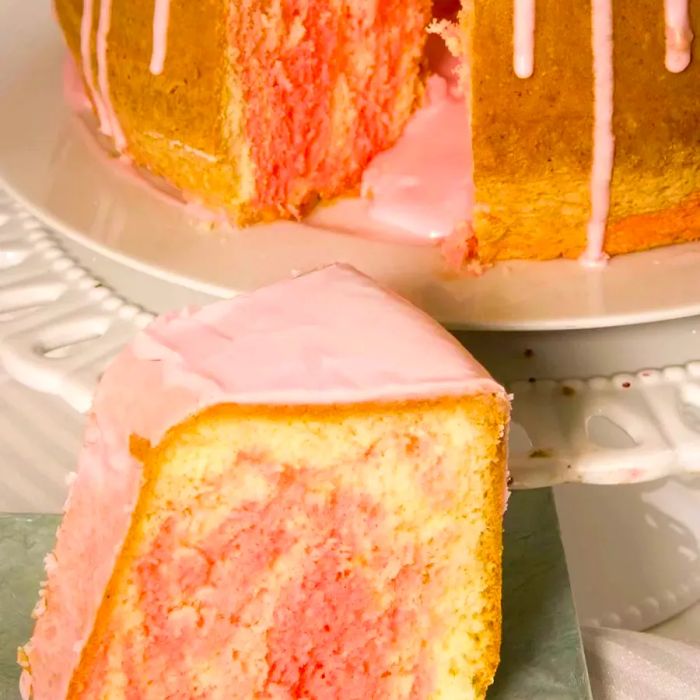 Peppermint chiffon bundt cake displayed on a cake stand and sliced.