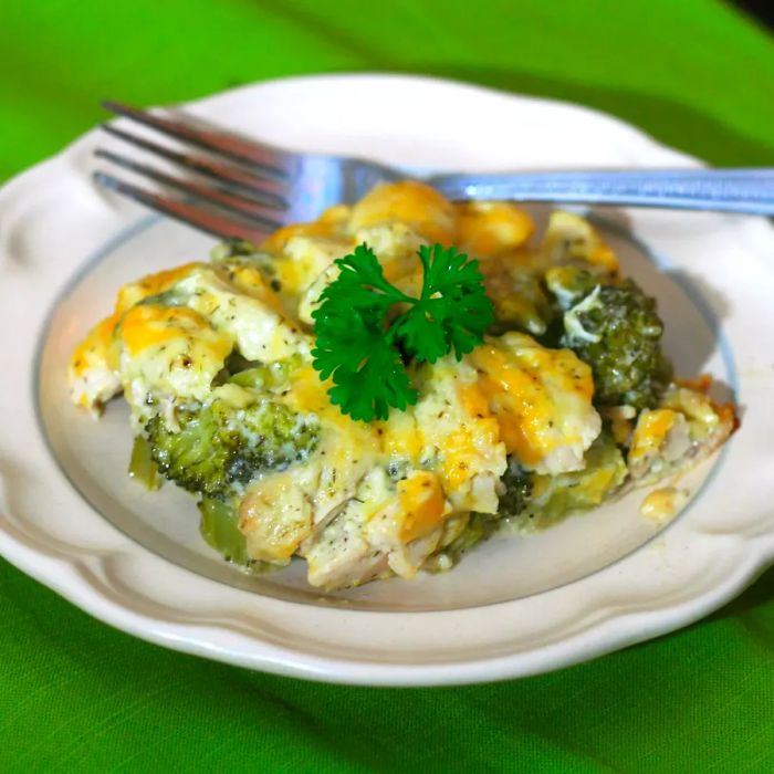 A white plate serving of casserole garnished with a sprig of parsley