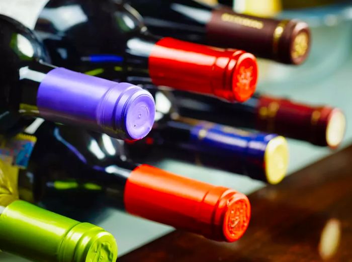 Wine bottles resting horizontally in a cellar, showcasing both red and white wines.