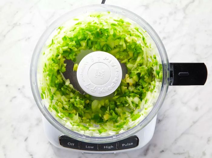 Onion and green bell pepper chopped in a food processor.
