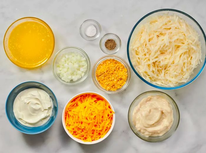 Bowls filled with all the ingredients needed for Grandma's delicious hash brown casserole recipe.