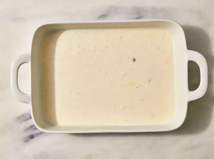 Creamy white sauce in a white baking dish