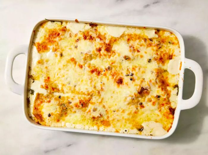 Golden-brown Baked Chicken and Spinach Alfredo Lasagna in a white baking dish