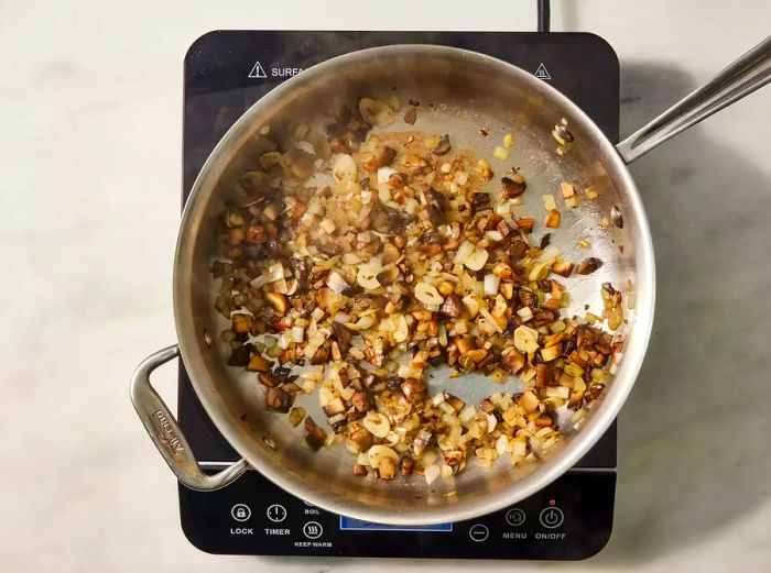Onions and mushrooms cooking in a pan on the stove