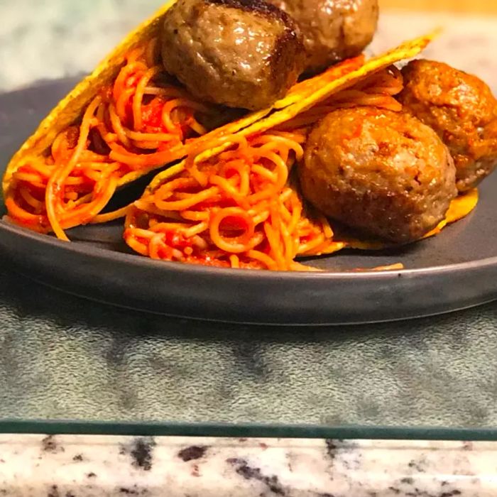 Spaghetti Tacos served on a grey plate
