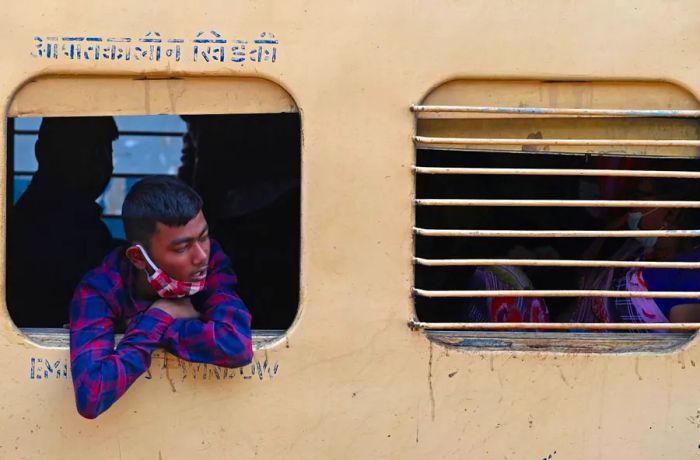 A passenger gazes out the window of a long-distance train at a Mumbai station on January 17, 2022.