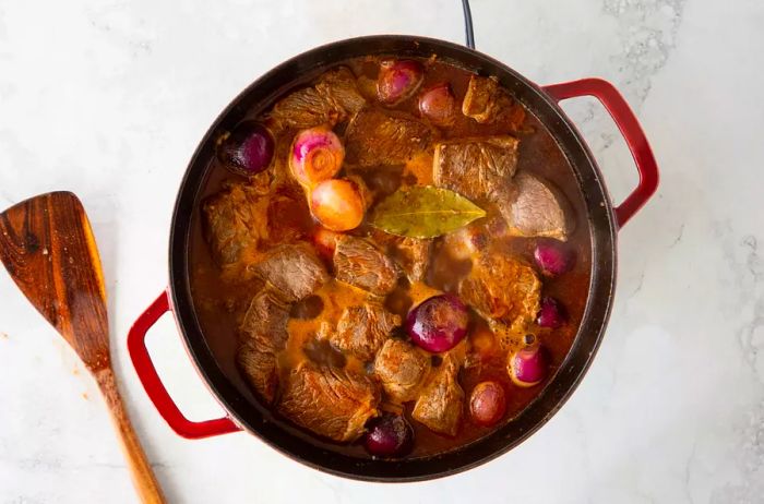 Greek-Style Beef Stew (Stifado) simmering in a pot, rich and flavorful.