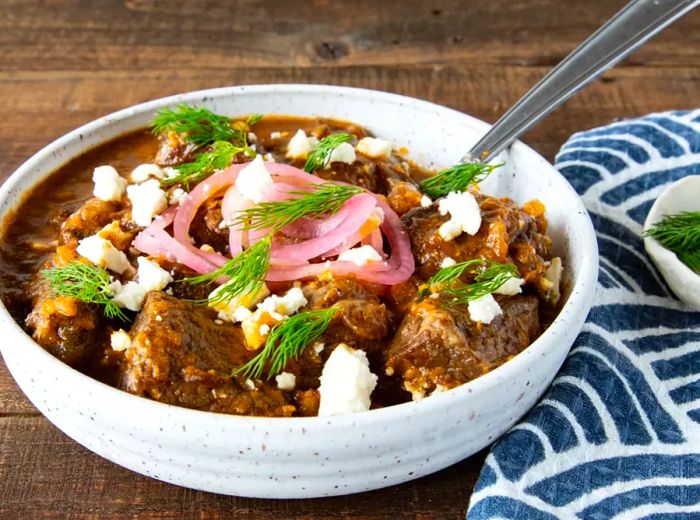 Greek-Style Beef Stew (Stifado) served in a pristine white bowl.