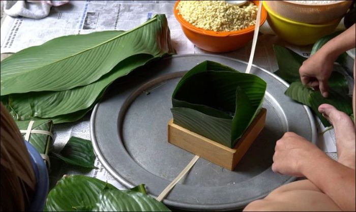 Sắp xếp lá dong vào khuôn bánh