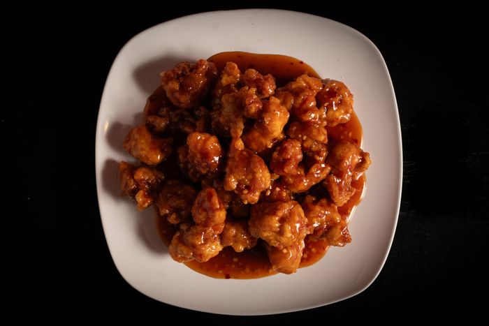 A plate of saucy fried chicken pieces, neatly arranged and viewed from above
