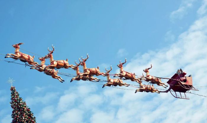 Ông già Noel và đàn tuần lộc di chuyển qua bầu trời đêm, mang đến niềm vui cho trẻ em trên khắp thế giới.