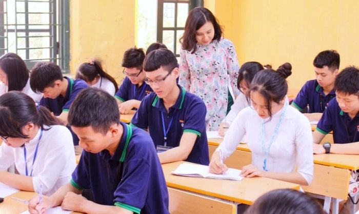 Hình ảnh cô giáo quan sát và hỗ trợ học sinh làm bài tập