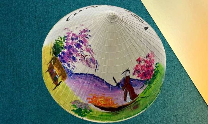 Trang trí nón lá 20/10 với chủ đề phong cảnh quê hương Việt Nam, đưa người xem về những cánh đồng lúa, dòng sông hiền hòa.