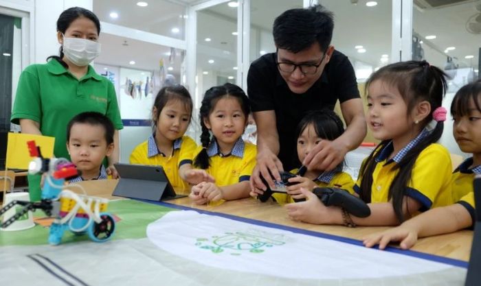 Hình ảnh thầy giáo hướng dẫn các bé lắp ráp mô hình