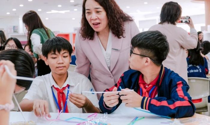 Cô giáo hướng dẫn học sinh thực hiện thí nghiệm khoa học