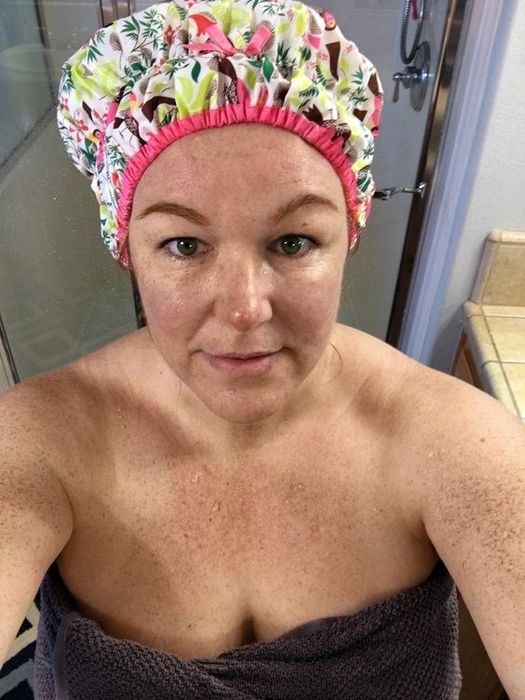 reviewer wrapped in a towel wearing a patterned shower cap