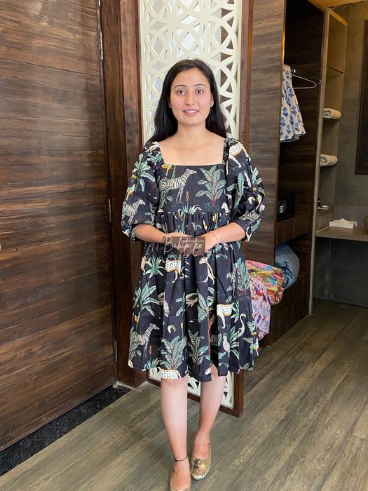 A person wearing a black dress featuring a striking tiger pattern