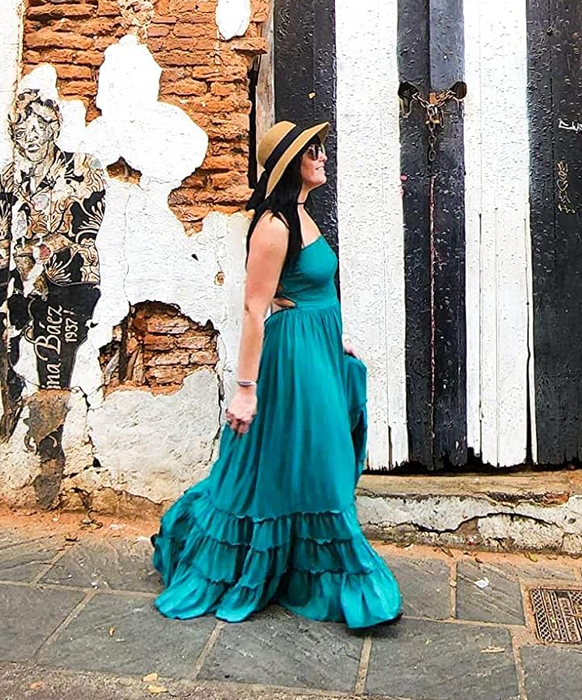 reviewer walking in a long blue backless dress