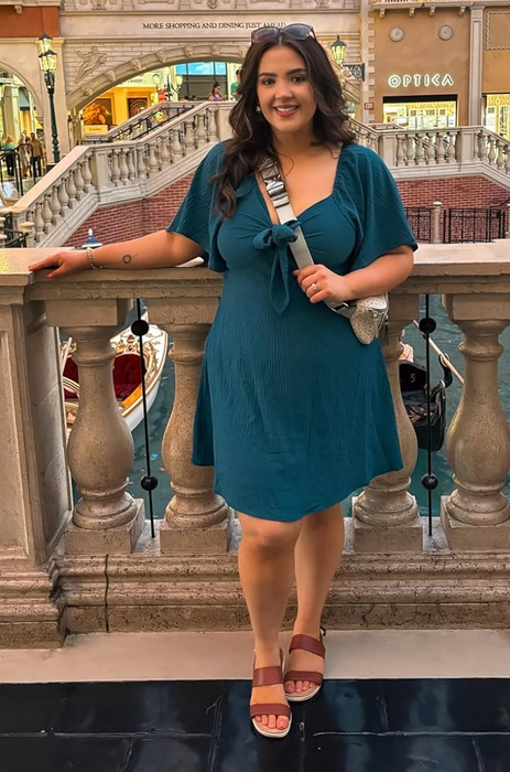 reviewer wearing a teal dress
