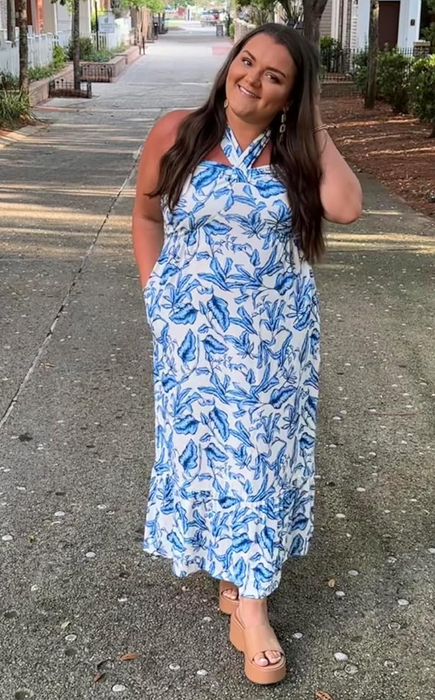 reviewer in a blue and white floral dress