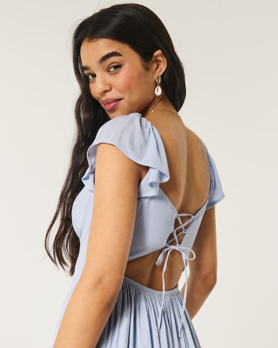 model showcasing the lace back of a blue dress