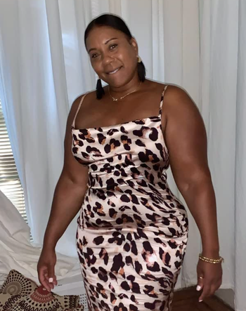 reviewer in a sleeveless leopard print strapless silk dress