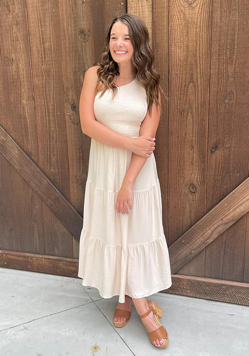 reviewer wearing a beige dress