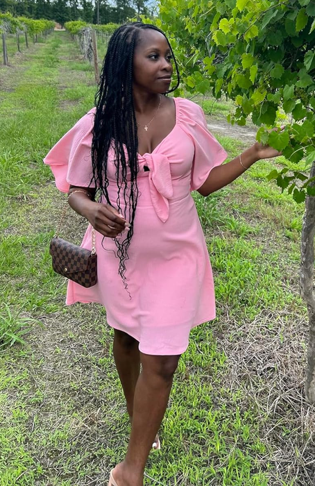 reviewer wearing a pink dress