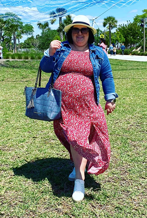 Reviewer wearing the red floral print dress paired with a denim jacket
