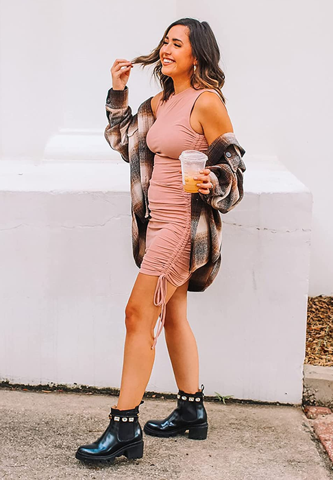 A model wearing the pink dress, showcasing the side view with drawstrings and ruched detailing
