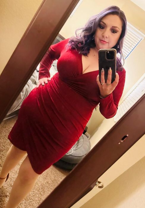 A person captures a mirror selfie in a stylish red dress featuring long sleeves and a wrap-style top, ideal for a glamorous evening or party ensemble.