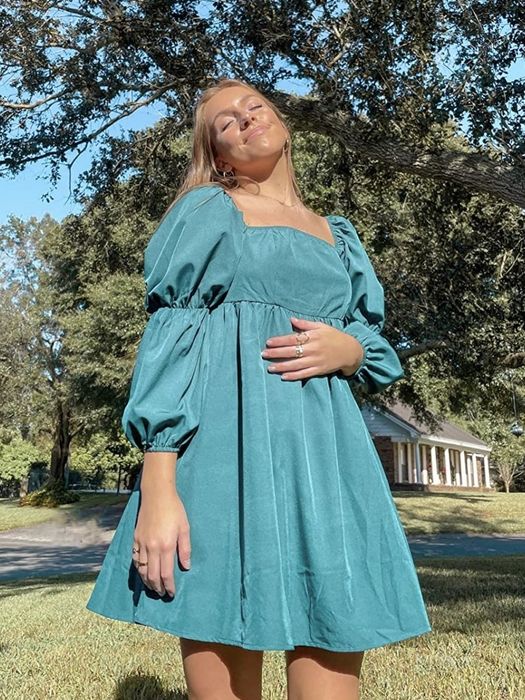 a reviewer modeling the teal version of the dress