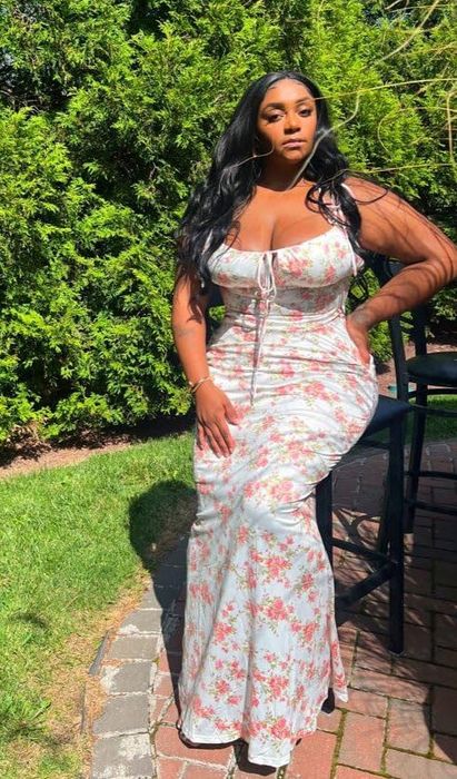 reviewer posing in the floral print dress