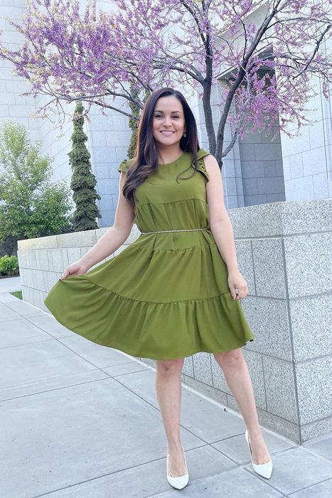 reviewer modeling the green tiered dress accessorized with a belt