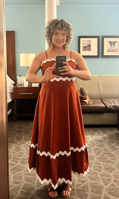 reviewer wearing the brick red version of the dress
