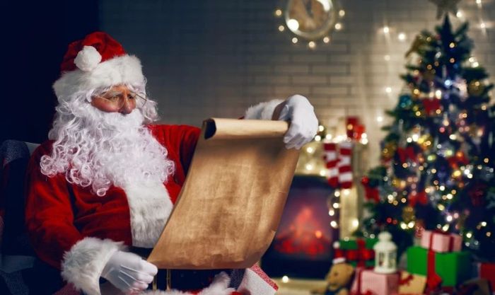 Ông già Noel đọc thư bên gốc cây thông