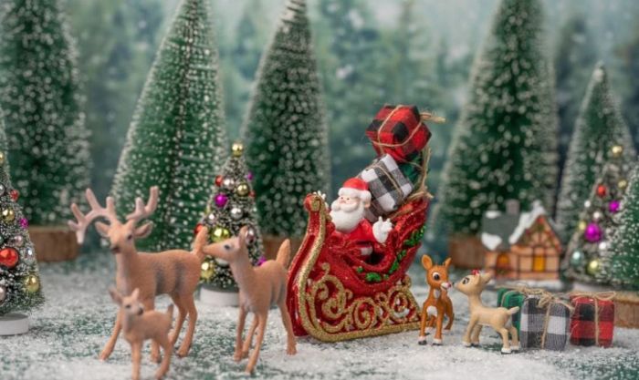 Hình ảnh ông già Noel đứng cạnh cây thông Noel