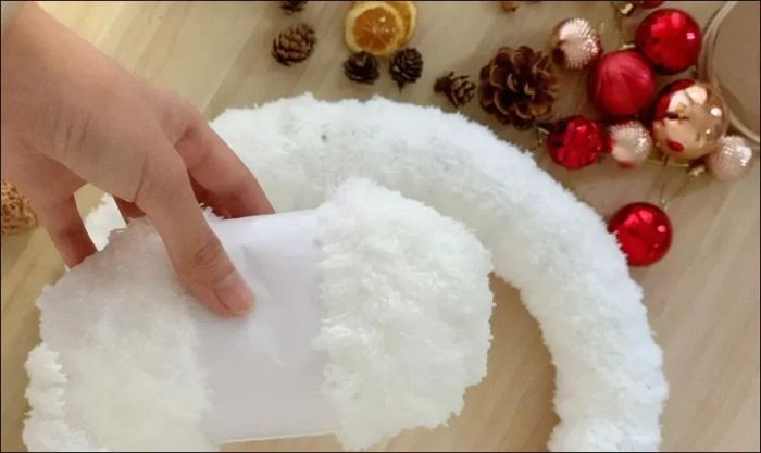 Quấn len lông xù quanh vòng nguyệt quế và sử dụng keo để cố định chắc chắn các phần len.