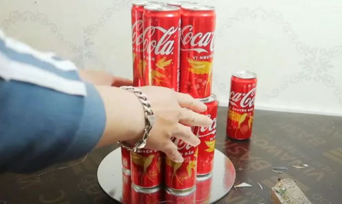 Xếp các lon nước lên tầng 2 sao cho cân đối và cố định chúng giống như tầng 1