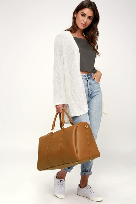 Model carrying a brown weekender bag