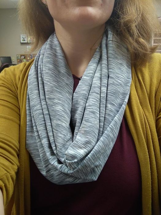 Reviewer wearing a light gray infinity scarf