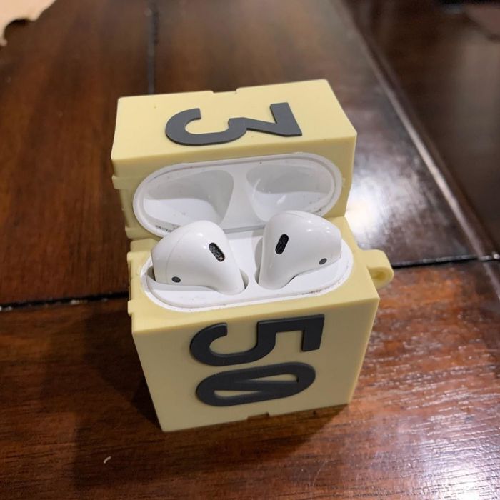 A reviewer’s AirPods snugly fitted inside the case