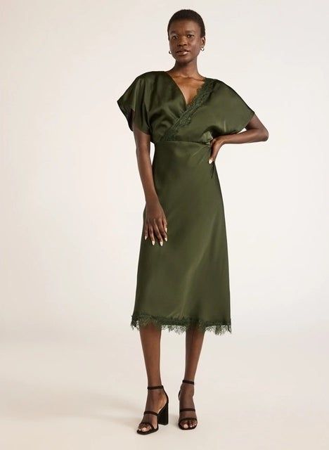 A model strikes a pose in the dress, complete with black heels for a chic look.