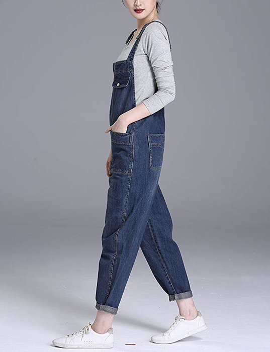 A model is styled in blue baggy overalls, paired with a gray shirt and white sneakers