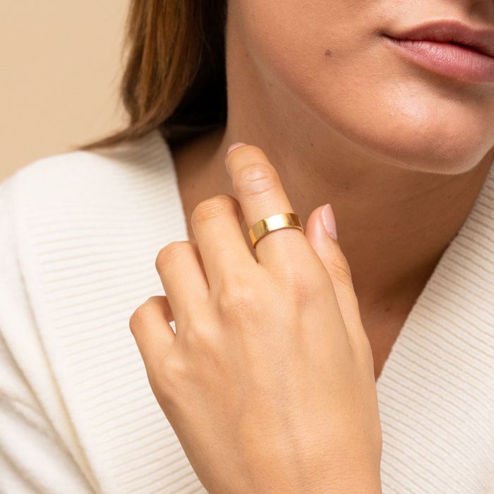Model wearing a gold ring on their index finger